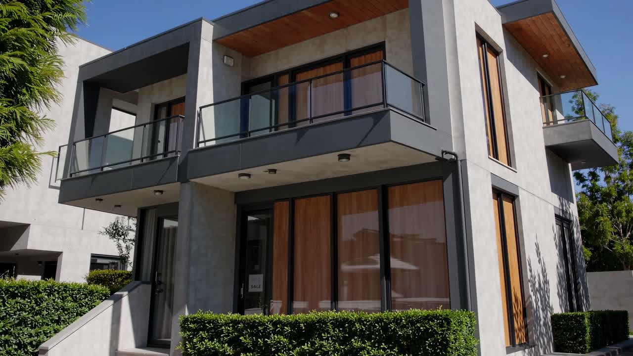 Modern duplex house featuring balconies, large windows, and a sleek design, offering a contemporary and stylish living space, available for sale in a desirable location