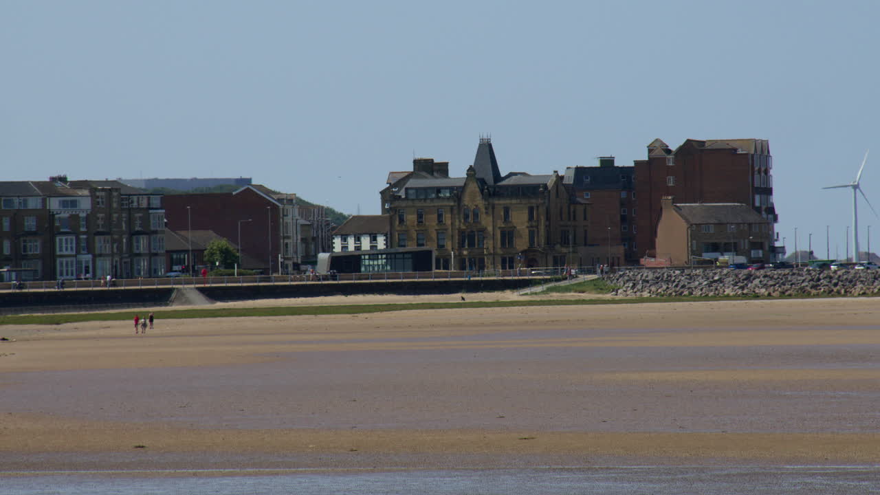 Plan large d’hôtels et de bâtiments sur le front de mer de Morecambe à marée basse, montrant les bancs de sable annulaires à la jetée de pierre