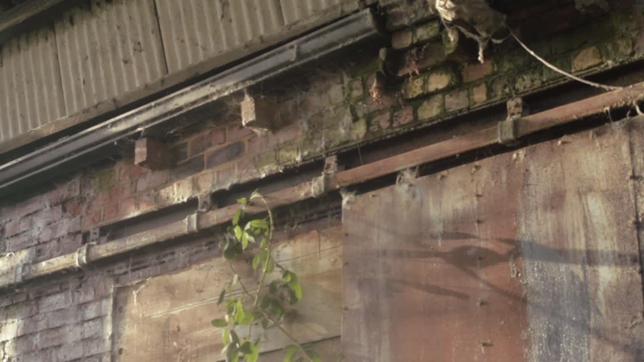 Outside of derelict abandoned brick building with rusty doors