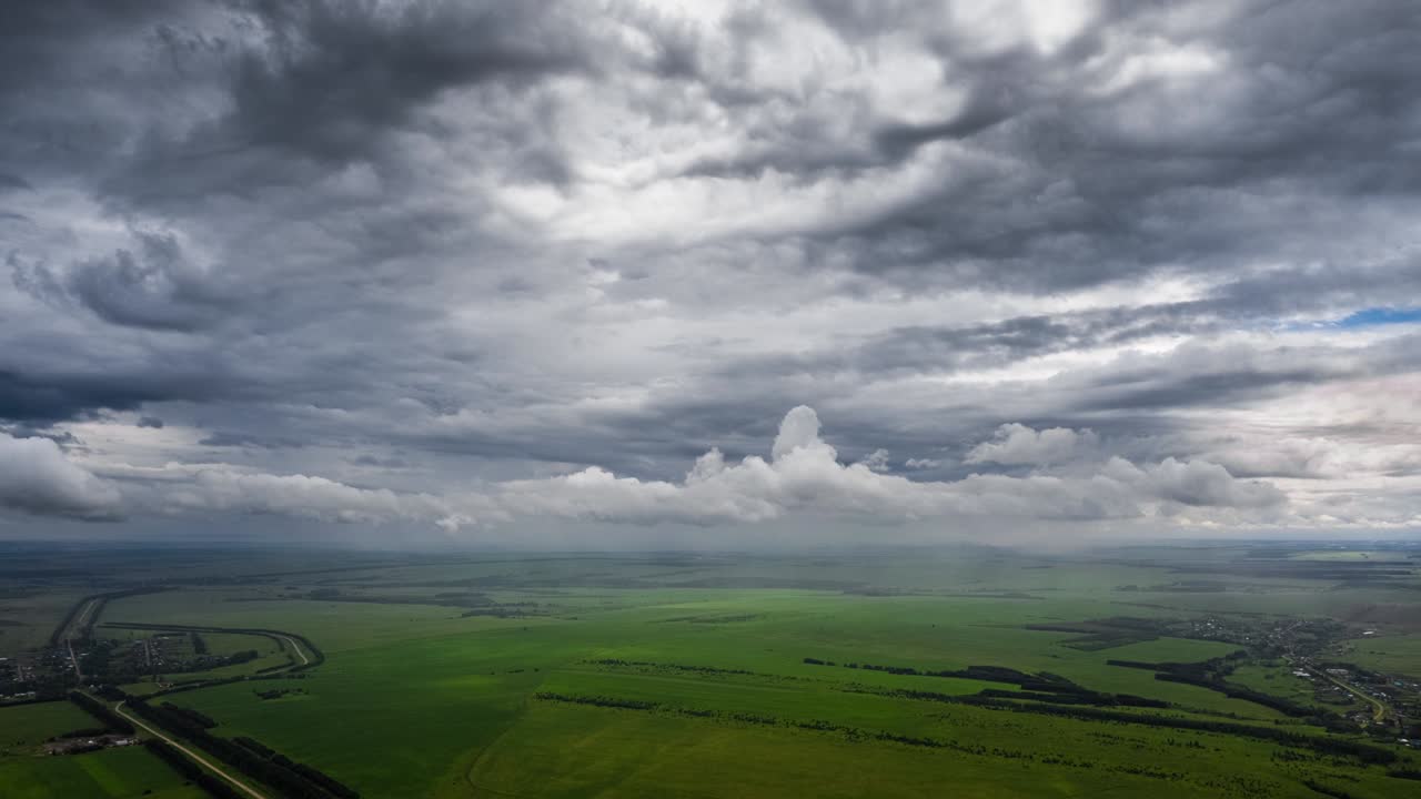 временный промежуток дождливого неба. воздушный промежутак времени штормового неба с дождливыми облаками, движущимися над сельской местностью