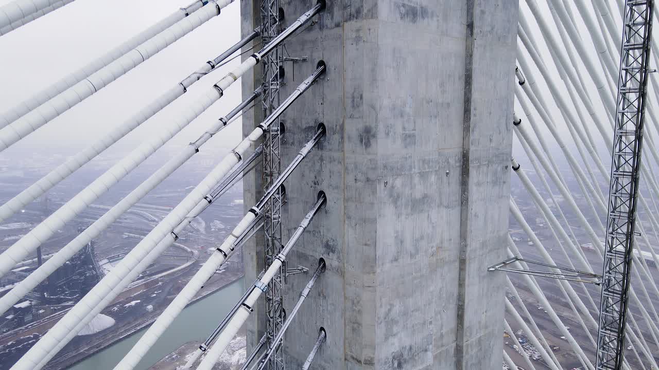 Close-up of suspension cables and concrete tower on Gordie Howe Bridge in winter