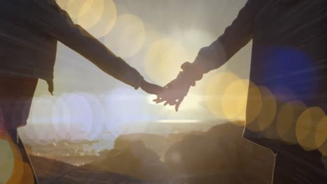 animation of light spots over african american couple walking and holding hands