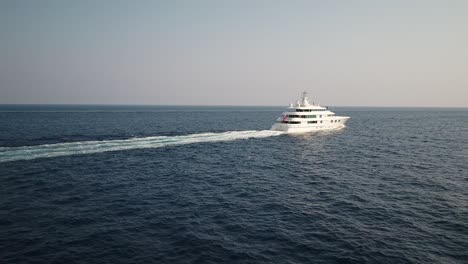 Aerial-view-following-behind-cruise-ship-moving-on-ocean-waves