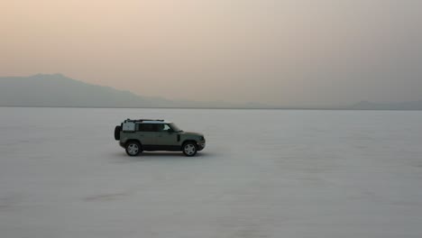 Geländewagen-Mit-Allradantrieb,-Der-Bei-Sonnenaufgang-Durch-Die-Salzwüste-Von-Bonneville-In-Tooele-County,-Utah,-Fährt