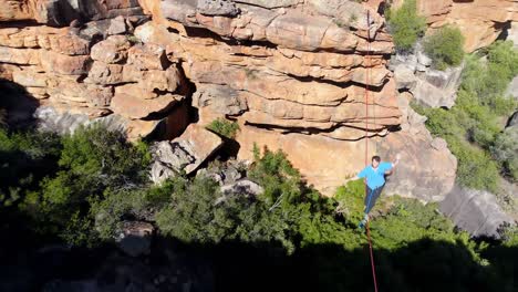 Male-highliner-walkng-on-a-rope-over-rocky-mountains-4k