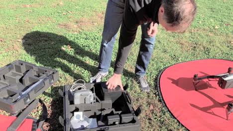 un operador de drones conecta la cámara al drone antes de despegar