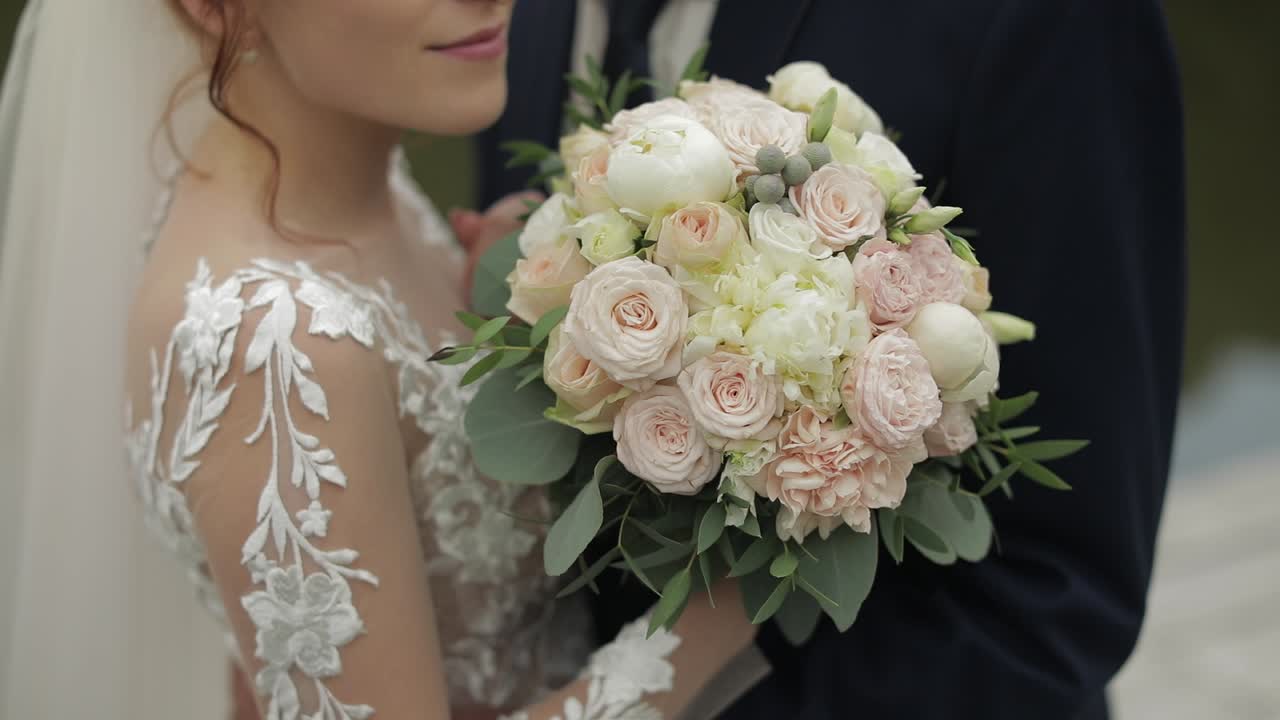 Sposo con la sposa vicino al lago nel parco. Coppia di sposi. Movimento lento