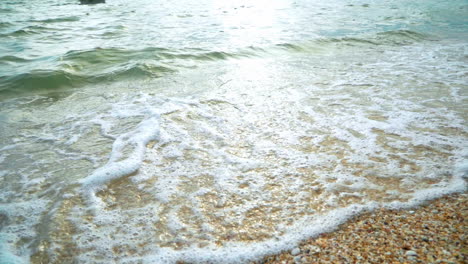 beautiful beach with waves reaching the shore of a white sand beach on a tropical during a sunset