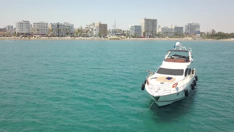 Orbit-Shot-Of-Luxurious-Small-Yacht-Anchored,-People-Enjoying-Their-Time-In-Blue-Sea,-Cyprus