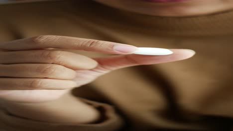 woman holding a white pill