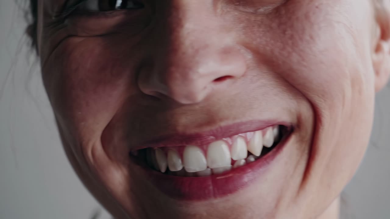 Close-up video of a smiling woman's face, capturing the texture and emotion