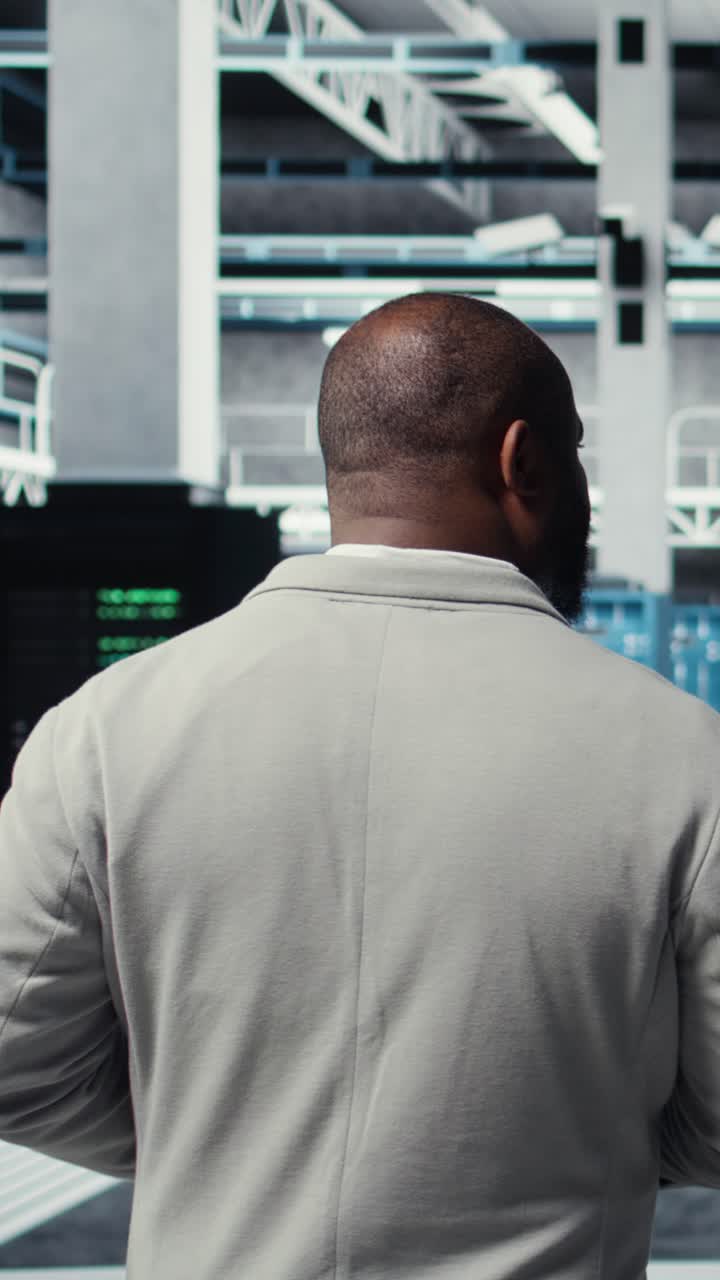 Vertical video Admin walking in high tech data center facility, checking equipment