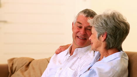 Happy-senior-couple-sitting-on-couch