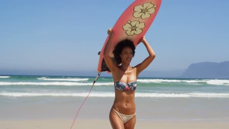 mulher correndo com prancha de surf na praia 4k