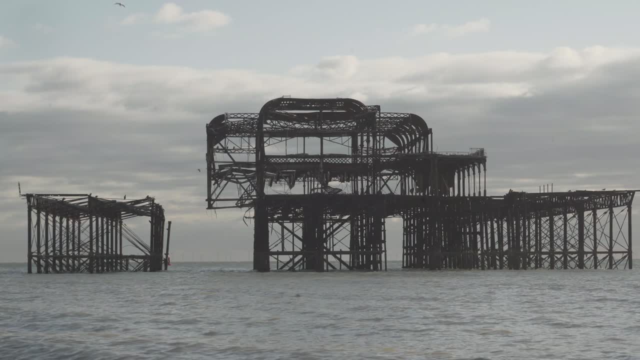 famous burnt pier in brighton city england uk. calm sea and some clouds in the sky