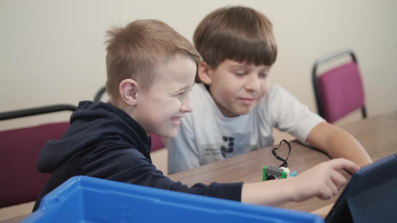 los niños participan en actividades de aprendizaje básico, montando kits de robótica con enfoque y trabajo en equipo en un entorno de aula