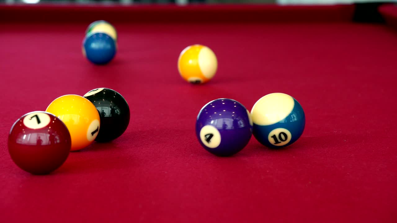 Playing the pool-billiard game on red baize table. This is sports