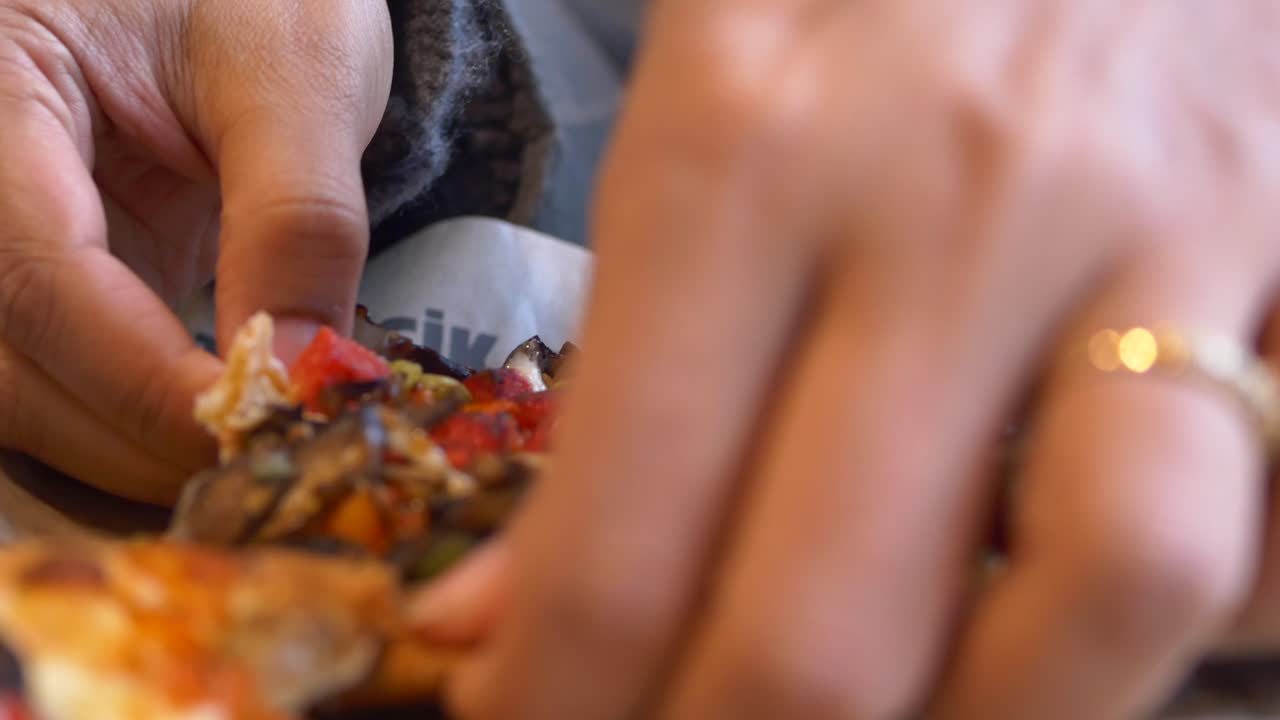 cerca de las manos comiendo una deliciosa pizza