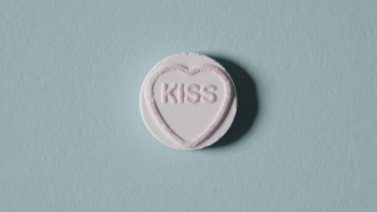 Heart Candy With Word Kiss On Blue Background