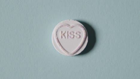 heart candy with word kiss on blue background