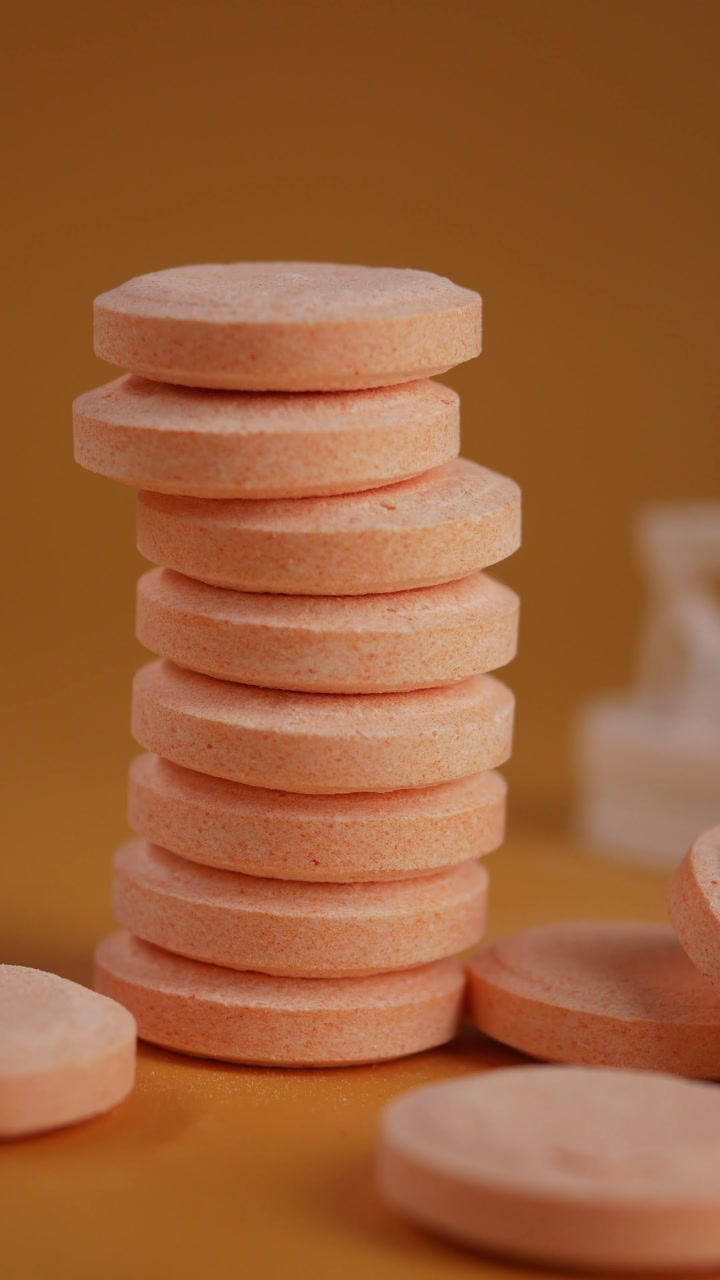 Stack of Orange Effervescent Tablets on Yellow Background