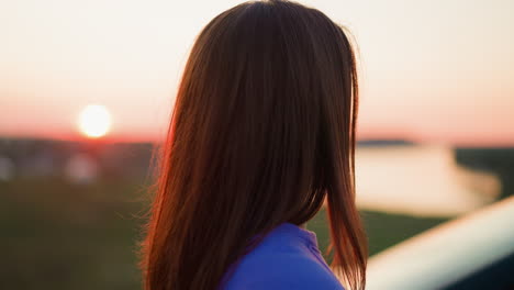 mujer viendo la puesta de sol sobre el río