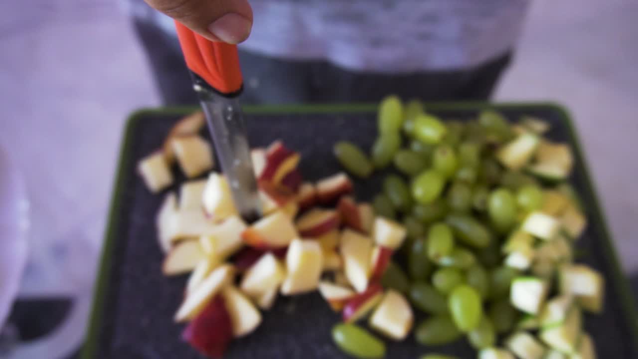 joven haciendo ensalada de frutas