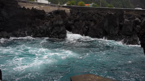rough atlantic ocean waves crashing on volcanic stones in faial, azores