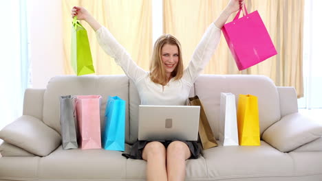 excited blonde shopping online on couch