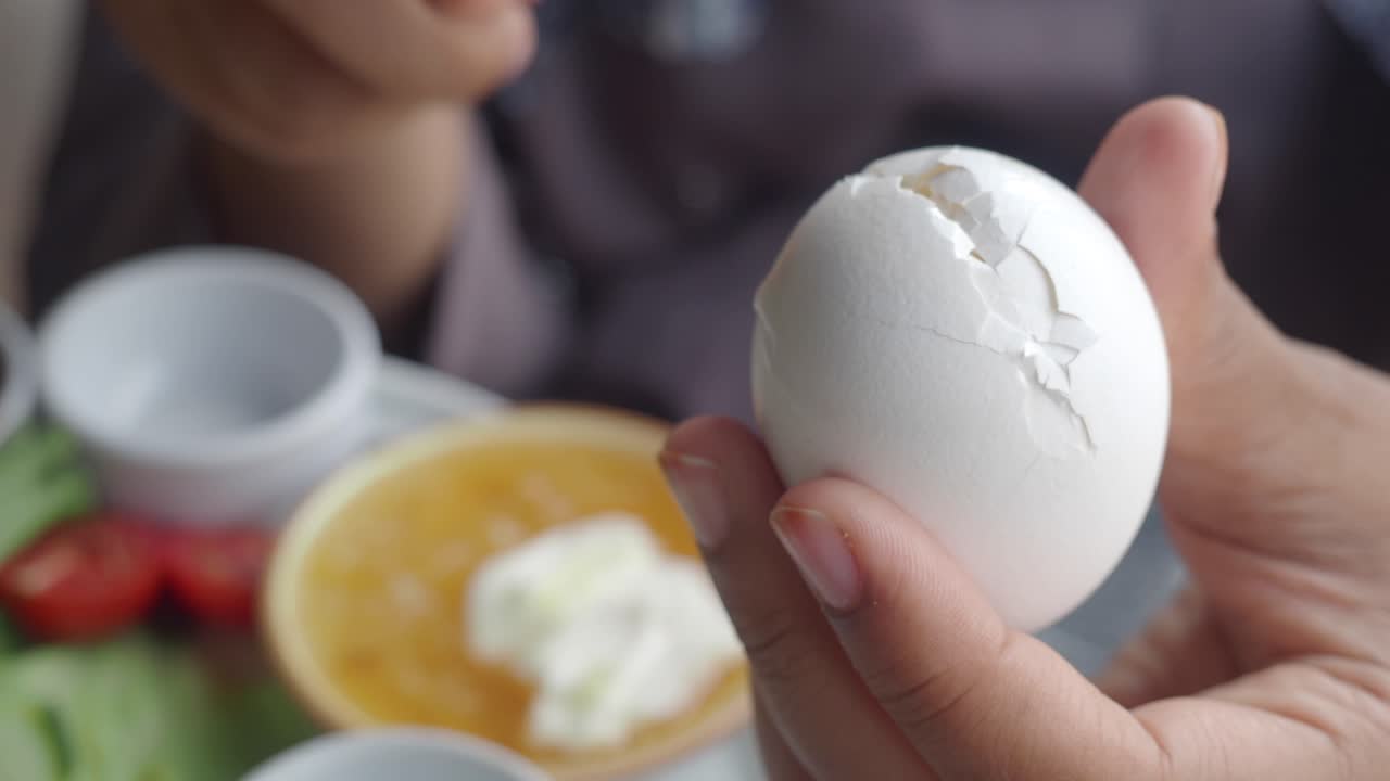 Person cracking and preparing an egg for breakfast.