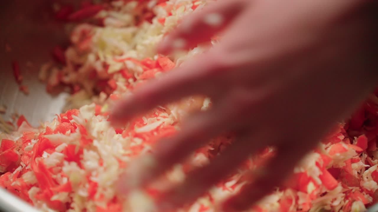 Hand mixing vegetable carrot and cabbage shreds
