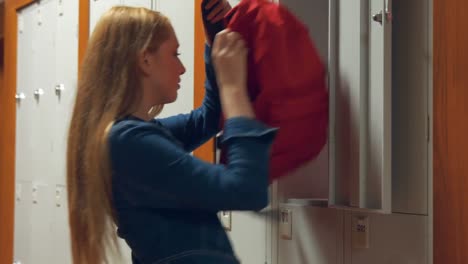 student gathering her school books from a locker