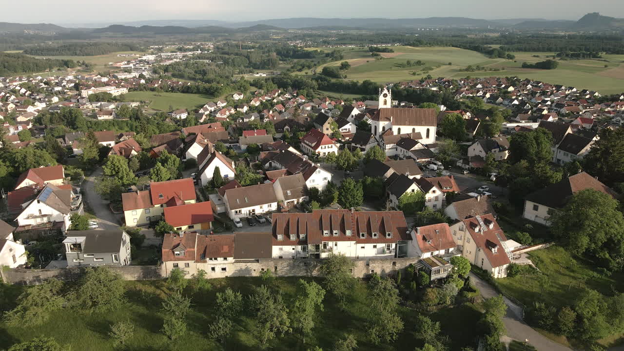 Drone footage descending over the historic old town of Aach, Baden-Württemberg, offering a detailed view of the village, its buildings, and the surrounding landscape.