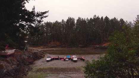 drone 4k footage of a boat launching dock at low tide exposing boats on land with a forest along the coasts