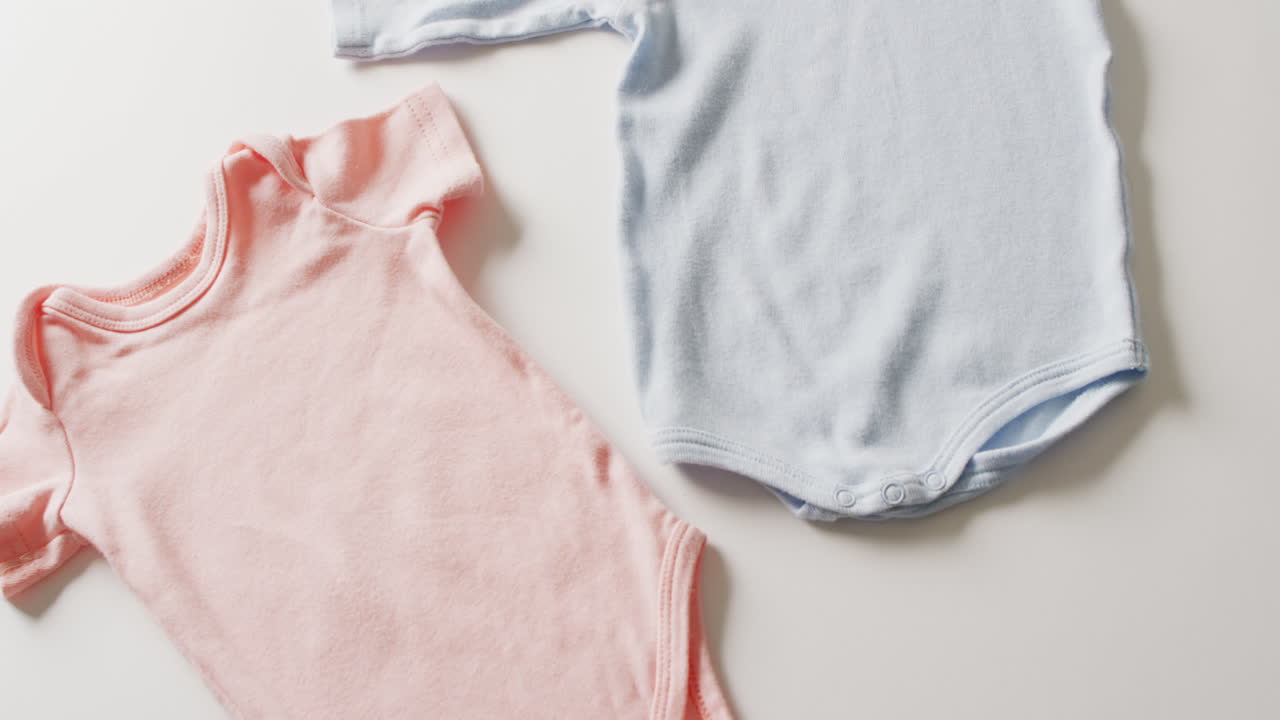 Video of close up of blue and pink baby grows on white background