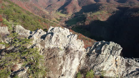 aerial view of man on top of steep rock formation, seneca rocks, west virginia usa on sunny fall day, drone shot