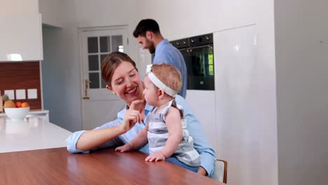 Happy-mother-playing-with-her-baby-in-the-kitchen