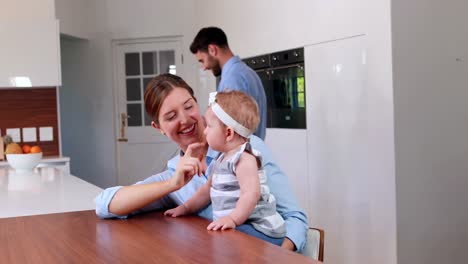 madre feliz jugando con su bebé en la cocina