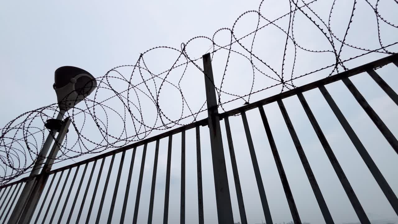 Barbed wire fence and street light
