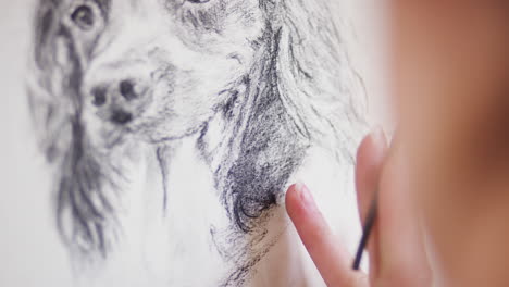 Close-Up-Of-Artist-Sitting-At-Easel-Drawing-Picture-Of-Dog-In-Charcoal