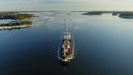Oil-and-Chemical-tanker-making-way-ahead-in-narrow-fairway-in-Finnish-archipelago-during-winter-evening