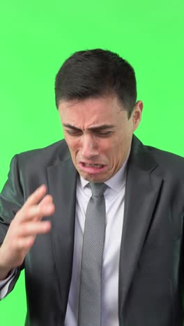 distressed businessman crying and expressing sadness on green screen