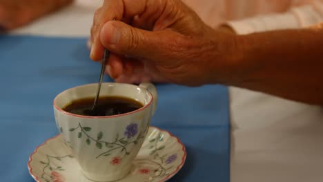 Close-up-of-hand-stirring-tea