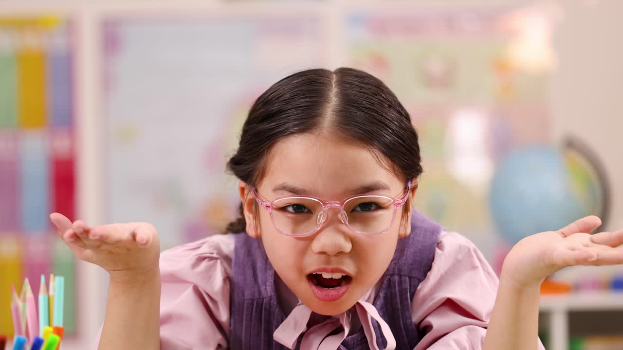 Cute schoolgirl in classroom makes exaggerated surprised gestures, bright colorful background, static close-up framing