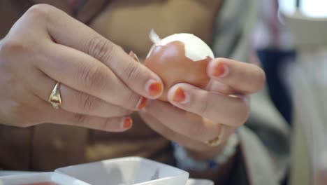 close-up of hands peeling a hard-boiled egg