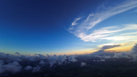 fpv drone turning around in the sky among the fluffy clouds. aerial perspective on the vast cityscape of a modern american city.