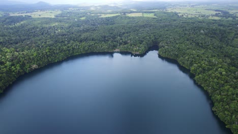 aerial view of eacham lake with tranquil waters and lush vegetation in atherton tableland, queensland, australia - drone shot