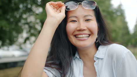 smiling woman wearing sunglasses in a park