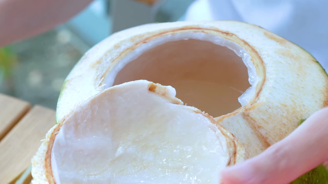 persona recogiendo carne de coco con una cuchara