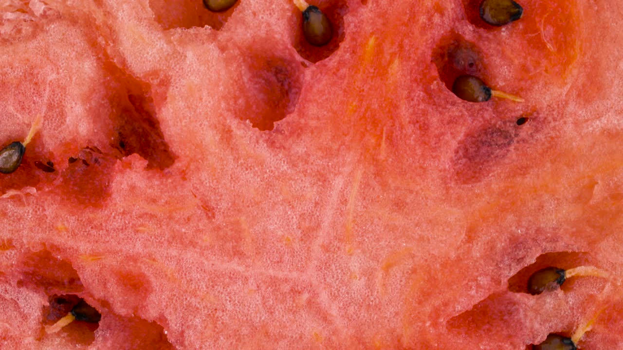disparo macro. vista superior desde arriba de una rebanada de sandía madura cortada a la mitad con semillas. sección transversal. girando en la mesa giratoria. primer plano.